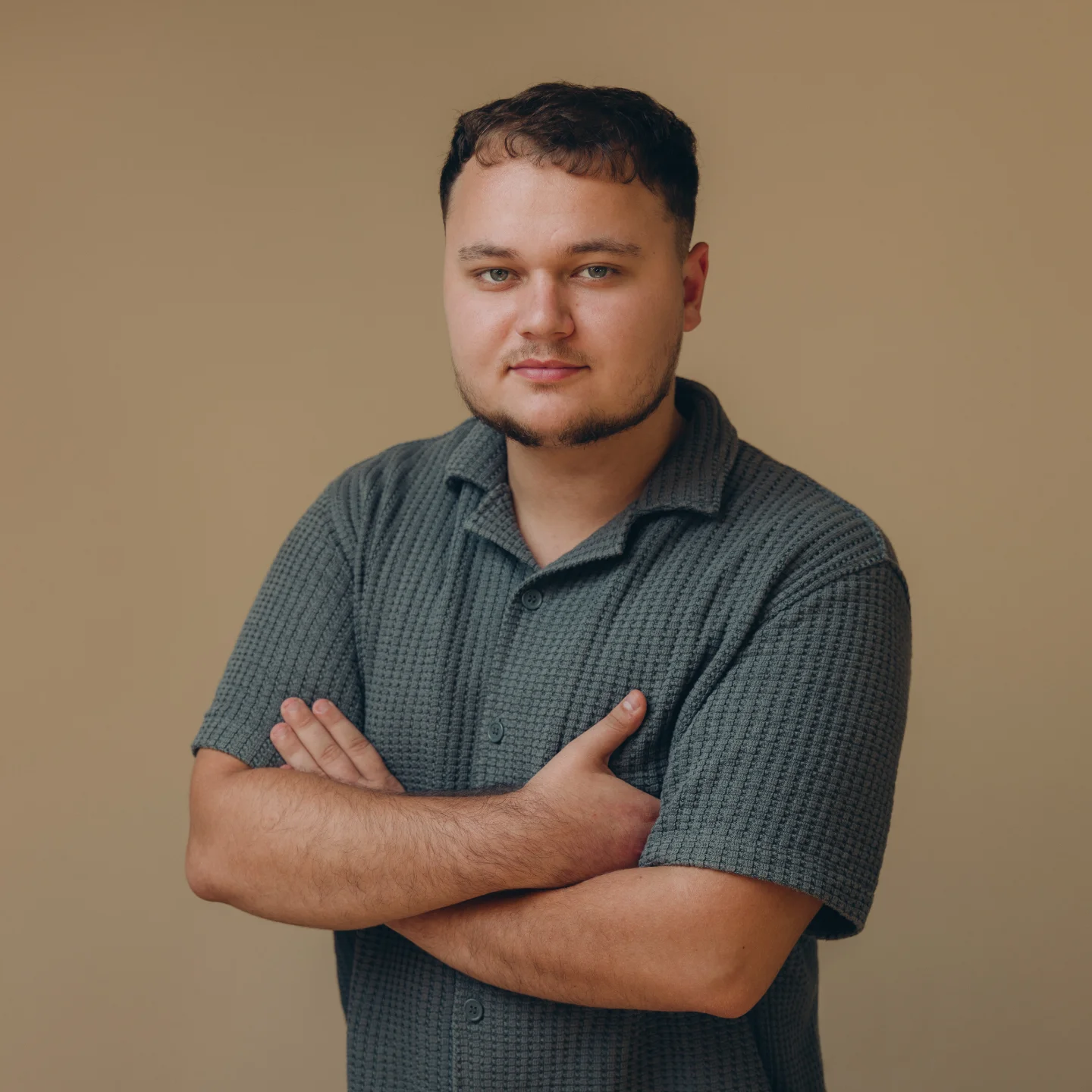 Team member portrait, arms crossed in a gray shirt